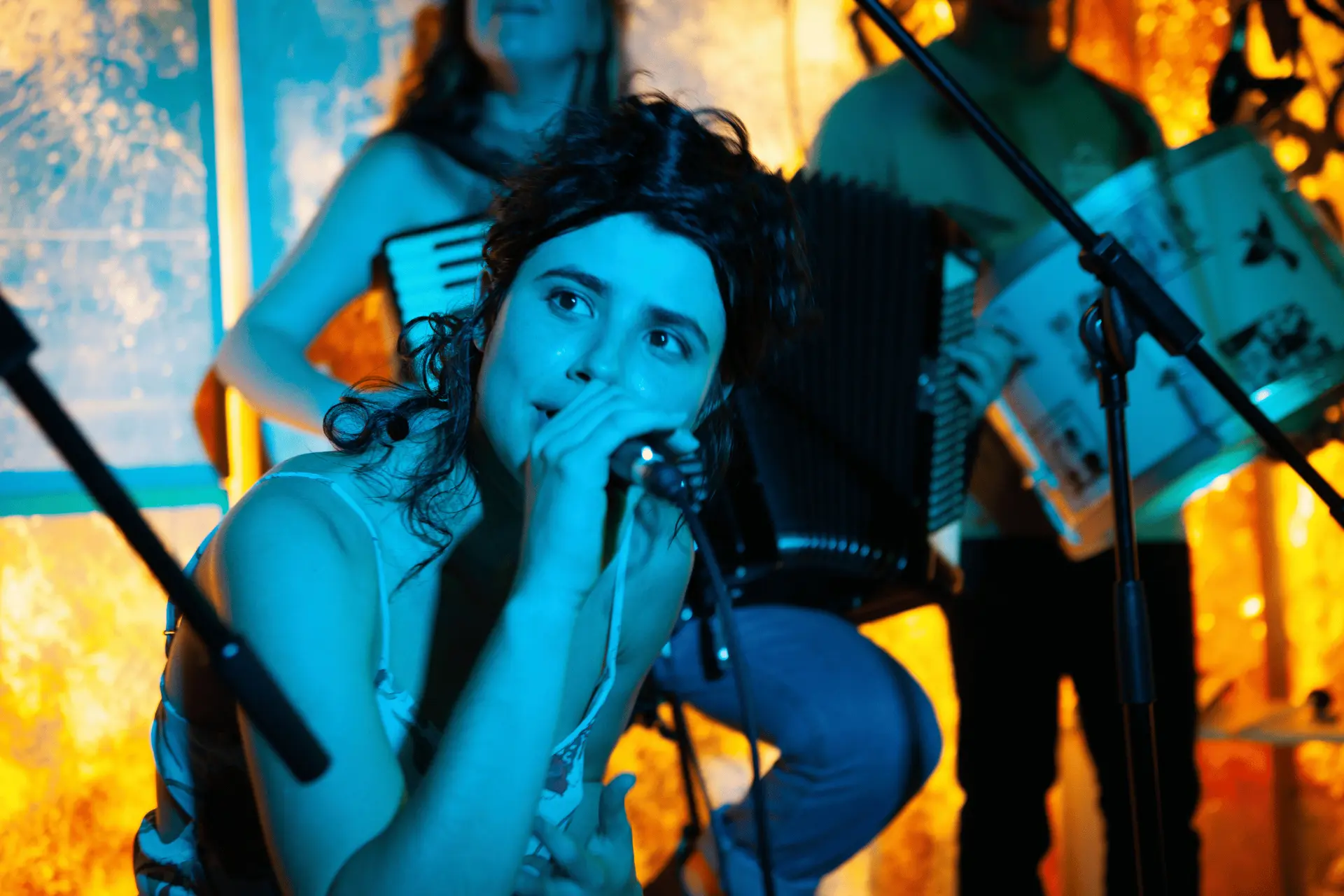 Sängerin mit Mikrofon vor Akkordeon bei einem Konzert im Forró Haus